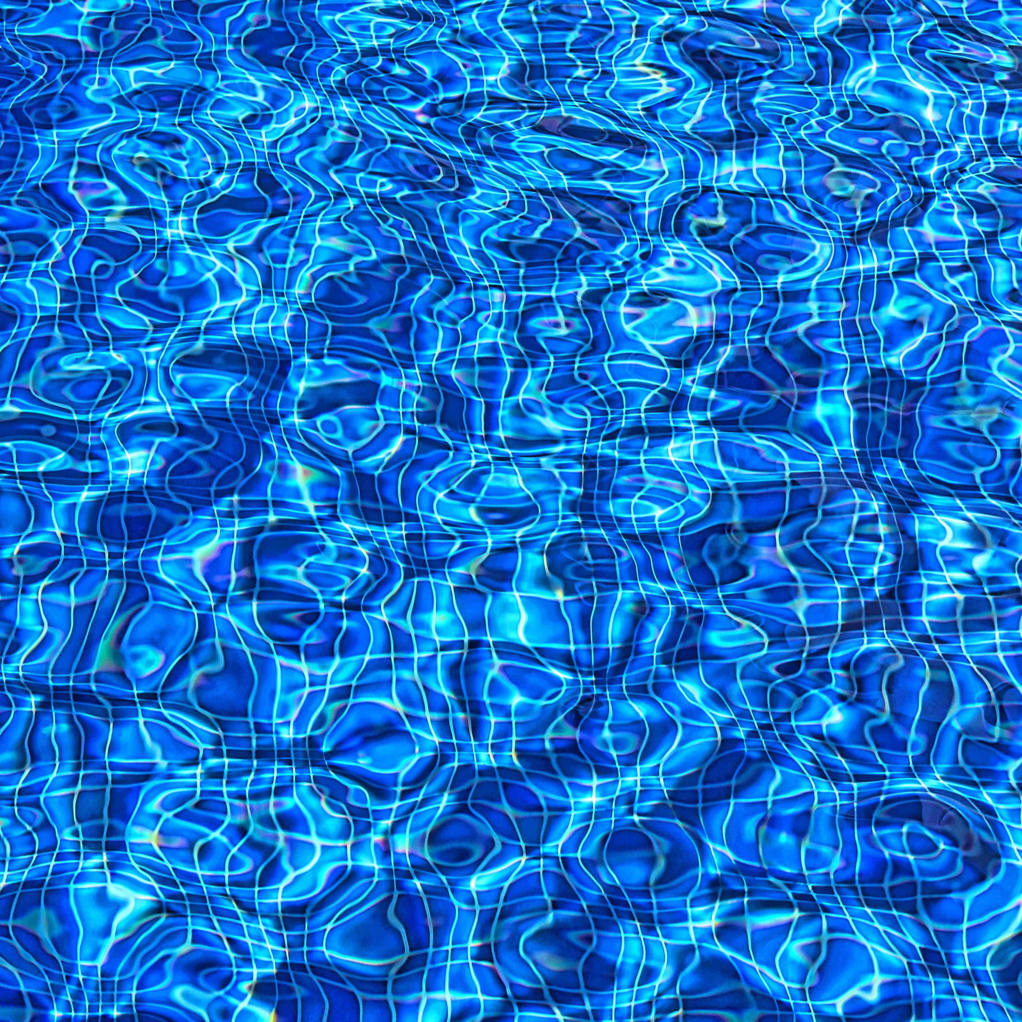Primer plano de test de calidad del agua en piscina, con tiras reactivas y sistema de autocontrol visible junto al borde