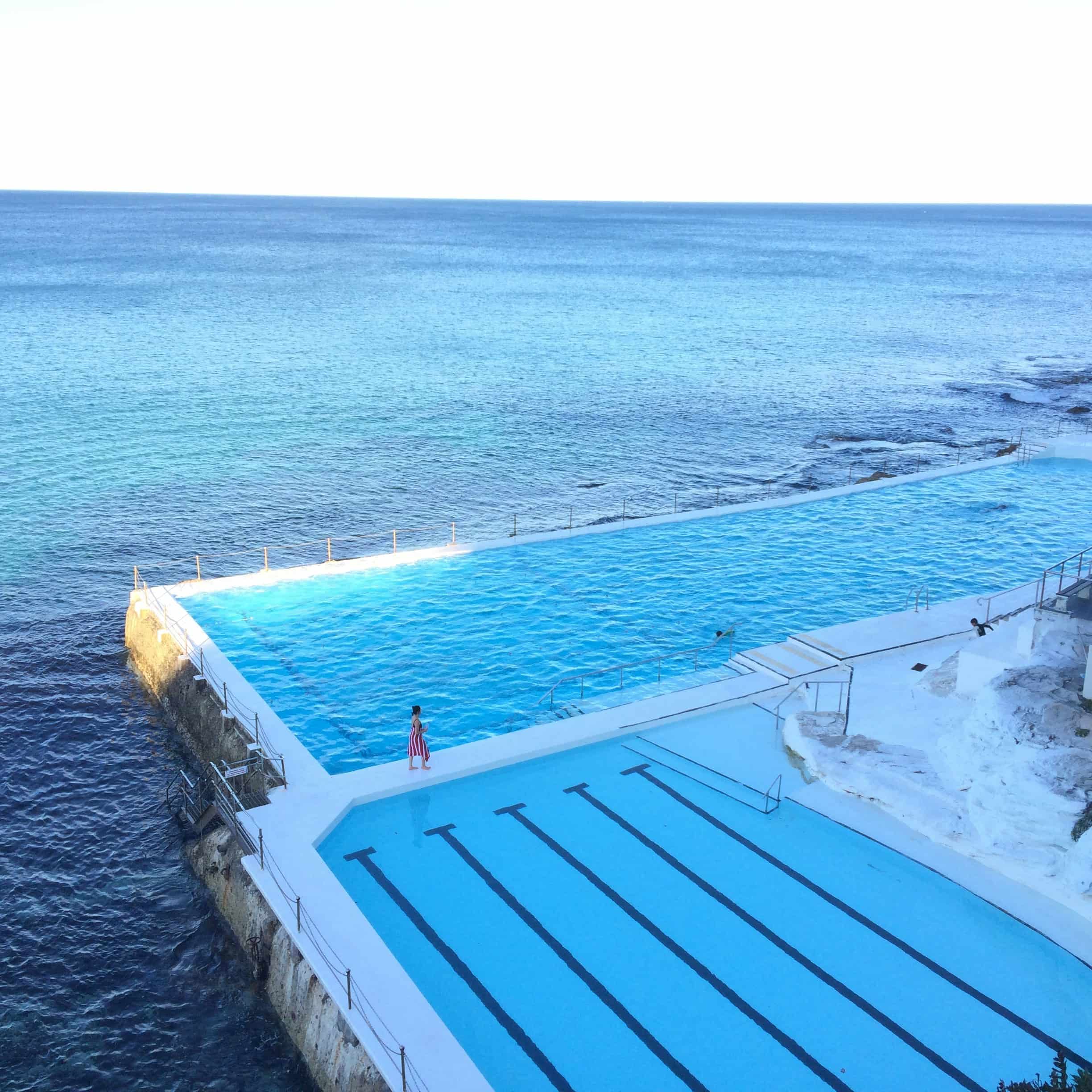 Comparativa de varios sistemas de gestión remota para piscinas, mostrando dispositivos móviles y paneles digitales junto a la piscina